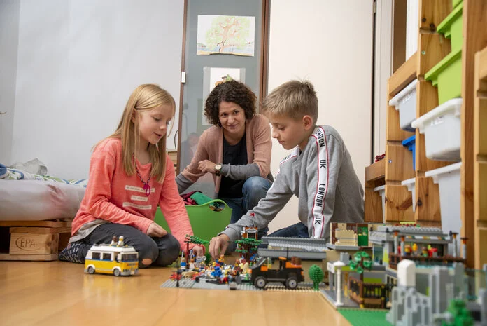 Mutter spielt mit Kindern, Tobias Schwerdt © Krebsinformationsdienst, DKFZ Mutter spielt zu Hause mit Kindern.