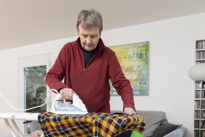 Wäsche bügeln, © Krebsinformationsdienst, DKFZ; Foto: Tobias Schwerdt Eine ältere Frau bügelt Wäsche.