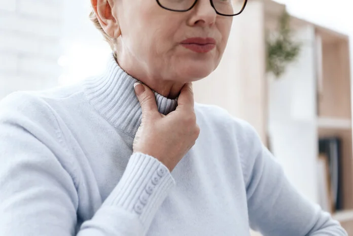Halsschmerzen, © T Turovska, iStock Eine Frau fasst sich an den Hals.