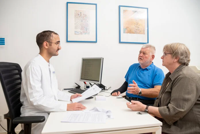 Gespräch mit dem Arzt, © Krebsinformationsdienst, DKFZ; Foto: Tobias Schwerdt Ein älteres Ehepaar sitzt einem Arzt gegenüber, während sie eine Unterhaltung führen.