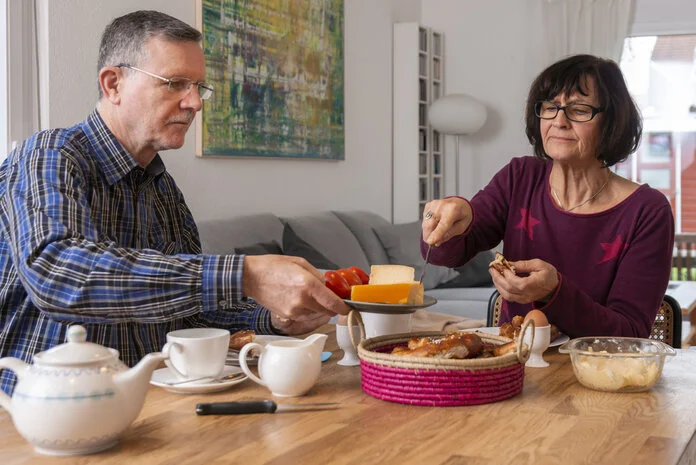 Ehepaar frühstückt, © Krebsinformationsdienst, DKFZ; Foto: Tobias Schwerdt Ein Mann und eine Frau sitzen beim Früstück im Esszimmer.
