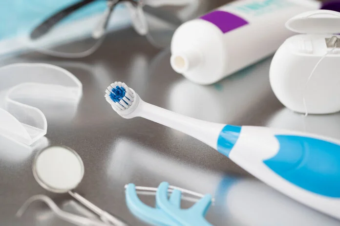 Zahnpflegeprodukte, © Daisy-Daisy, iStock Verschiedene Utensilien für die Zahnpflege bei Krebs liegen auf einem Tisch: elektrische Zahnbürste, Zahnpasta, Zahnseide, Spiegel etc.