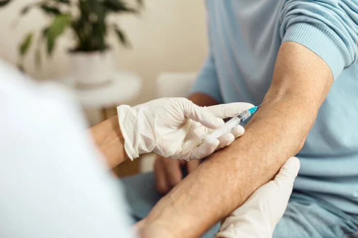 Medikamente verabreichen, © yacobchuk, iStock Mann bekommt etwas in die Vene gespritzt.