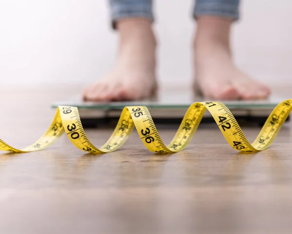 Waage und Maßband, © puhimec, iStock Füße auf einer Waage mit Maßband davor