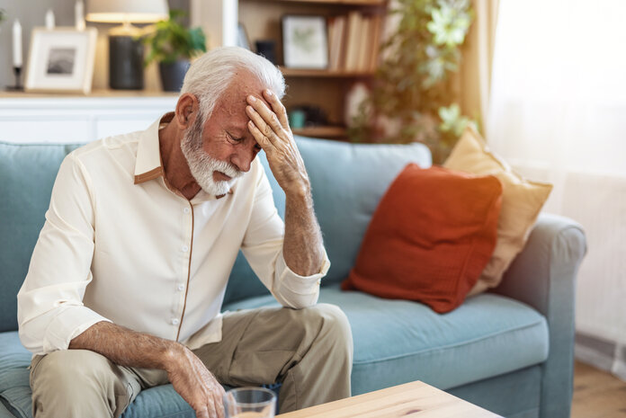 Erschöpfung, © Jelena Stanojkovic, Adobe Stock Mann sitzt erschöpft auf dem Sofa
