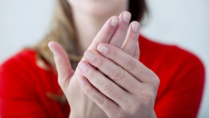 Neuropathie der Hände, © Image Point Fr, Shutterstock Junge Frau reibt sich die Hände