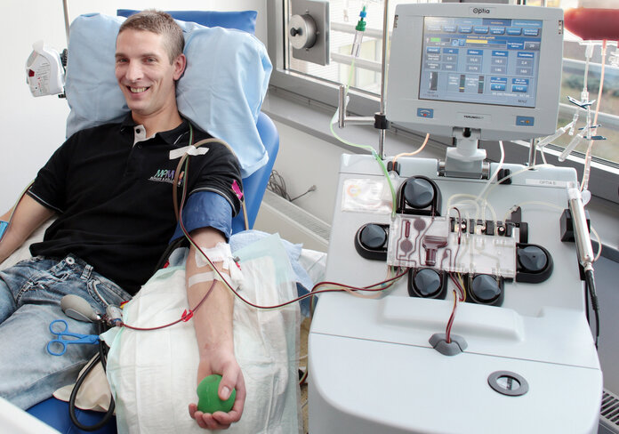 Junger Mann lächelt, während der Stammzellspende.