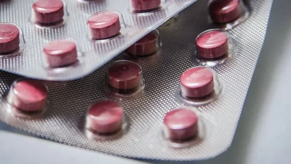 2 Blister mit roten Tabletten (Pillen).
