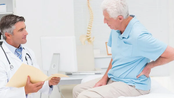 Arztgespräch, © ESB Professional, Shutterstock Arzt spricht mit einem Patienten, der auf einer Liege sitzt
