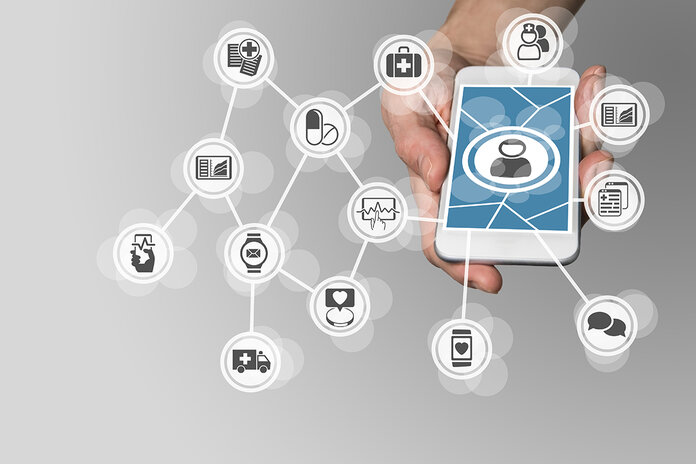 Eine Hand hält ein Smartphone, das von verschiedenen medizinischen Symbolen umgeben ist.