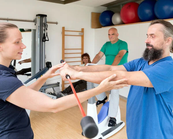 Rehasport, © Krebsinformationsdienst, DKFZ; Foto: Tobias Schwerdt Ein Mann trainiert mit einer Physiotherapeutin in einem Sportraum.