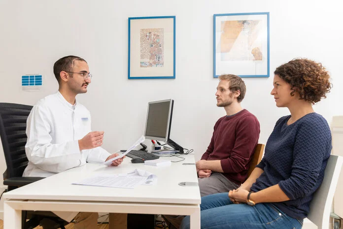 Arztgespräch, Tobias Schwerdt © Krebsinformationsdienst, DKFZ; Ein Mann und eine Frau sitzen einem Arzt bei der Sprechstunde gegenüber.