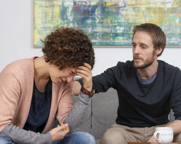 Junges Paar im Gespräch, © Krebsinformationsdienst, DKFZ Junge Frau und ihr Partner unterhalten sich auf einem Sofa.