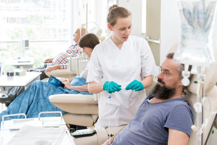 Pflegerin und Patient in der Chemo-Ambulanz, © Krebsinformationsdienst, DKFZ; Foto: Tobias Schwerdt Ein Mann bekommt eine Chemotherapie, eine Krankenschwester spricht mit ihm.
