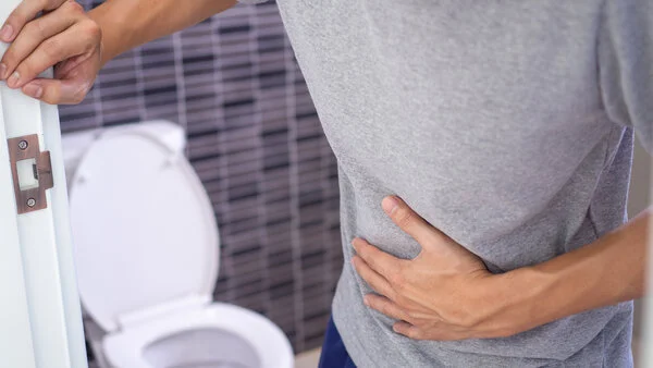 Mann bei Toilette hat Bauchschmerzen