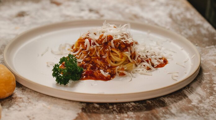 Spaghetti, © Klaus Nielsen, Pexels Eine kleine Portion Nudeln mit Sauce auf einem großen weißen Teller.