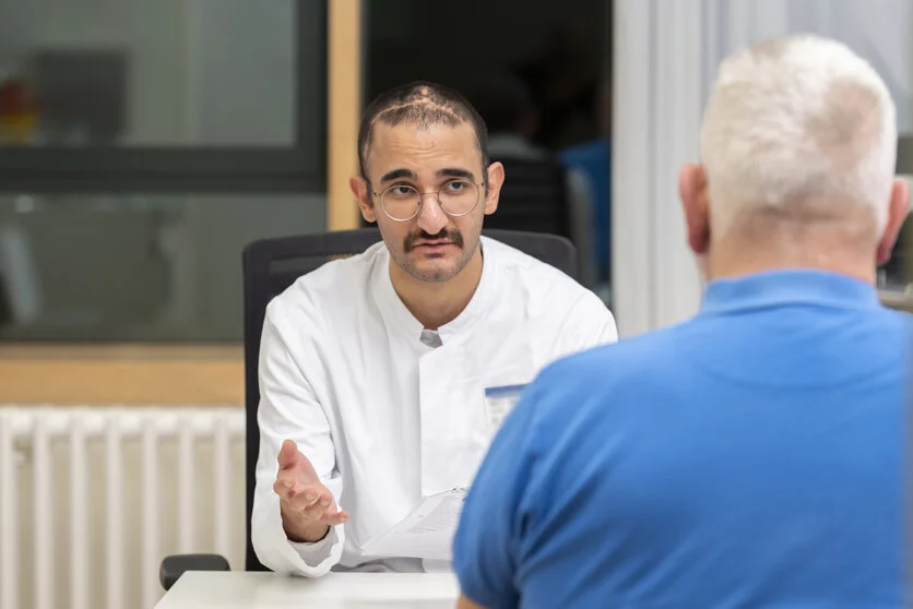 Gespräch mit dem Arzt, © Krebsinformationsdienst, DKFZ; Foto: Tobias Schwerdt Ein Arzt erklärt einem Patienten etwas.