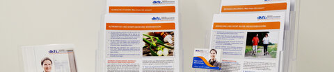 Tisch mit Flyern und Informationsblättern zum Thema Krebs sowie eine Visitenkarte des Krebsinformationsdienstes.