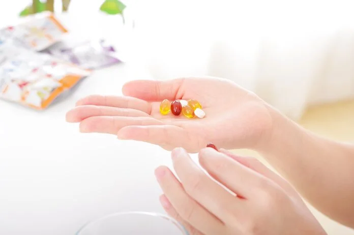 Nahrungsergänzungsmittel, © beauty-box, Shutterstock Eine Hand hält mehrere bunte Kapseln und Tabletten.