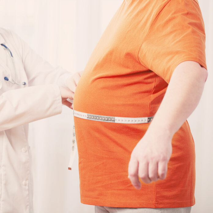 Vergrößerter Bauchumfang durch Aszites, © Maya23K, iStock Eine Ärztin misst mit einem Maßband den Bauchumfang eines Patienten.