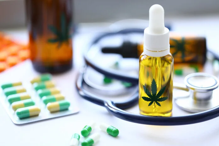 Kapseln, Tropffläschchen mit einem abgebildeten Cannabisblatt und Stethoskop