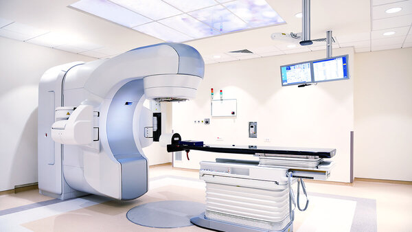 Untersuchungsraum mit elektrischer Untersuchungsliege und Linearbeschleuniger zur Strahlentherapie.