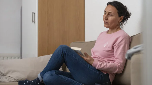 Nachdenklich, © Krebsinformationsdienst, DKFZ; Foto: Tobias Schwerdt Nachdenkliche Frau sitzt auf dem Sofa