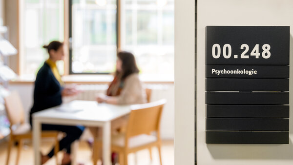 Eine Frau spricht in einem Raum in einer Klinik mit einer Psychoonkologin.