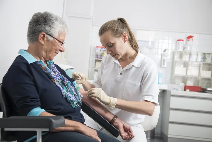 Blutabnahme, © Tobias Schwerdt; Krebsinformationsdienst, DKFZ Eine Arzthelferin nimmt einer Patientin Blut ab.