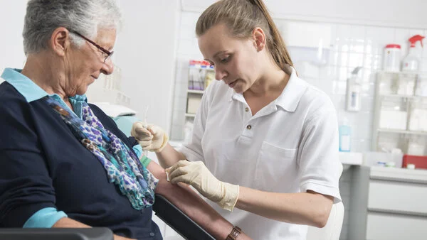 Blutabnahme, © Tobias Schwerdt; Krebsinformationsdienst, DKFZ Eine Arzthelferin nimmt einer Patientin Blut ab.
