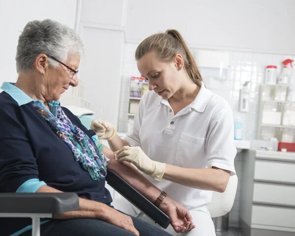 Blutabnahme, © Tobias Schwerdt; Krebsinformationsdienst, DKFZ Eine Arzthelferin nimmt einer Patientin Blut ab.