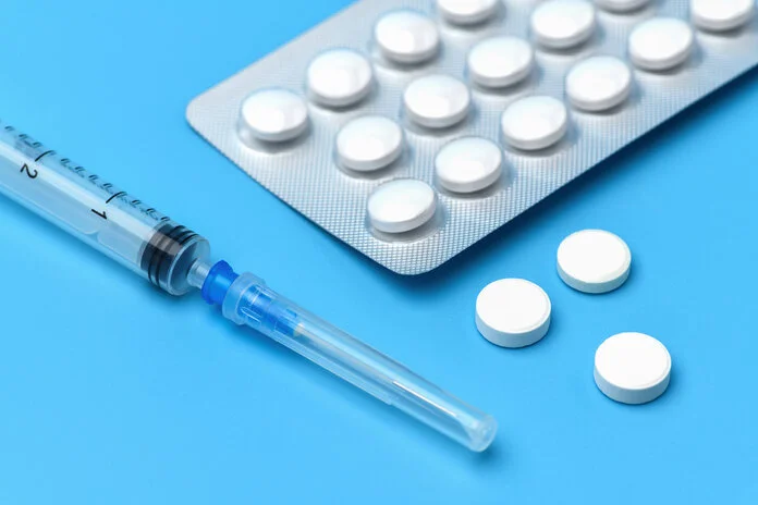 Medikamente, © Bk87, Shutterstock Neben einem Blister mit weißen Tabletten liegt eine Spritze.