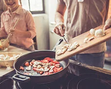 Eine ausgewogene Ernährung ist gesund und senkt das Krebsrisiko. © George Rudy, Shutterstock, © George Rudy, Shutterstock Familie kocht gemeinsam eine Gemüsepfanne