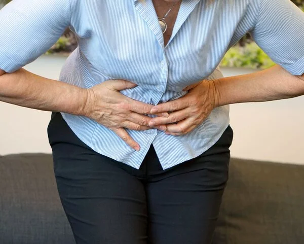 Unterleibschmerzen, © lunopark, Shutterstock Frau hält sich schmerzgekrümmt die Hände an den Unterleib
