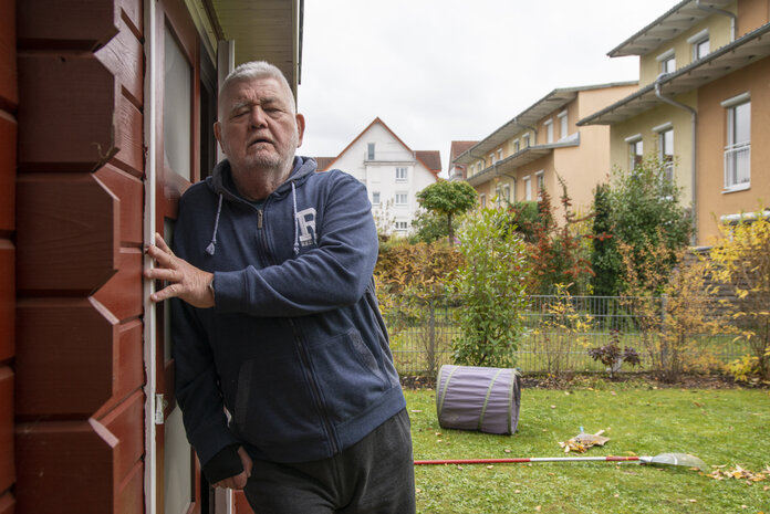 Erschöpfung im Alltag, © Krebsinformationsdienst, DKFZ; Foto: Tobias Schwerdt Mann stützt sich erschöpft am Gartenhaus ab.