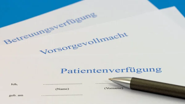 Patientenverfügung und Co., © M. Schuppich, Shutterstock Auf einem Tisch liegen eine Patientenverfügung, eine Vorsorgevollmacht und eine Betreuungsverfügung, darauf liegt ein Stift.