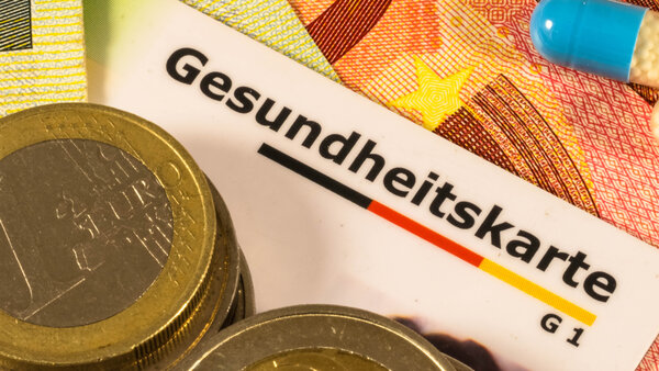 Gesundheitskarte und Geld als Symbole für Zuzahlungen in der gesetzlichen Krankenversicherung