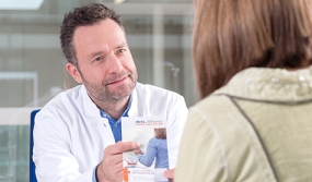 Arzt gibt Patientin Flyer, Foto: Tobias Schwerdt © Krebsinformationsdienst, Deutsches Krebsforschungszentrum, Krebsinformationsdienst, Deutsches Krebsforschungszentrum Arzt gibt Patientin Flyer, Foto: Tobias Schwerdt © Krebsinformationsdienst, Deutsches Krebsforschungszentrum