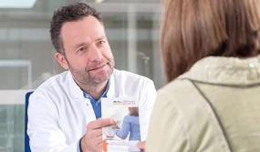 Arzt gibt Patientin Flyer, Foto: Tobias Schwerdt © Krebsinformationsdienst, Deutsches Krebsforschungszentrum, Krebsinformationsdienst, Deutsches Krebsforschungszentrum Arzt gibt Patientin Flyer, Foto: Tobias Schwerdt © Krebsinformationsdienst, Deutsches Krebsforschungszentrum