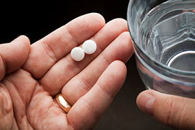 Frau hält Tabletten und Wasserglas in der Hand Frau hält Tabletten und Wasserglas in der Hand © leventince - Getty Images